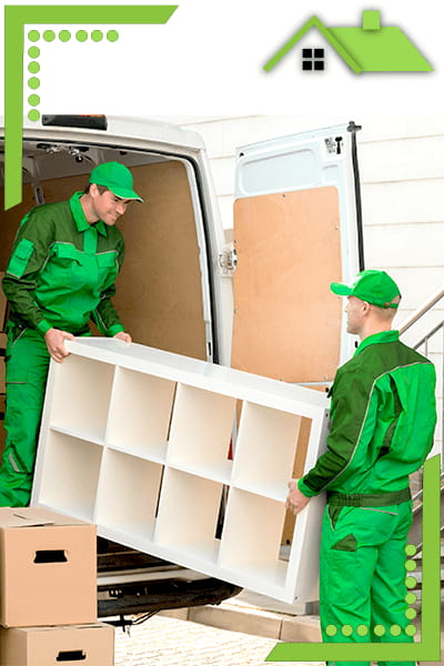 Zwei Mitarbeiter in grünen Uniformen tragen einen Bücherschrank und laden ihn in einen Kleinbus